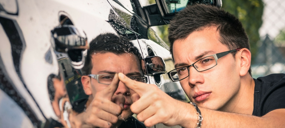 A man inspecting the outside of a car in a blog post about used cars