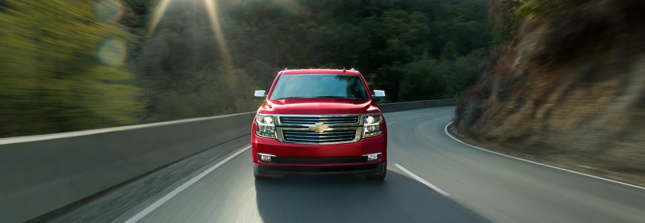 Red 2019 Chevrolet Tahoe driving down a winding road